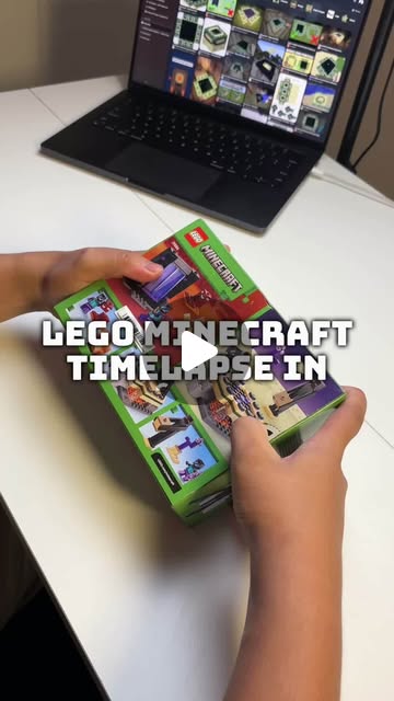 Hands opening a LEGO Minecraft box on a build desk