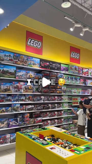A child looking at shelves of LEGO sets inside a LEGO store